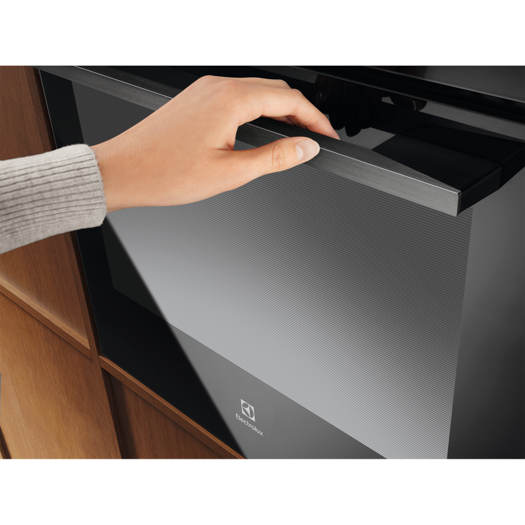 Electrolux KOFBC38H 60 cm 500 SurroundCook built-in single oven, 72 L, close-up of a hand opening the door by the stainless steel bar handle