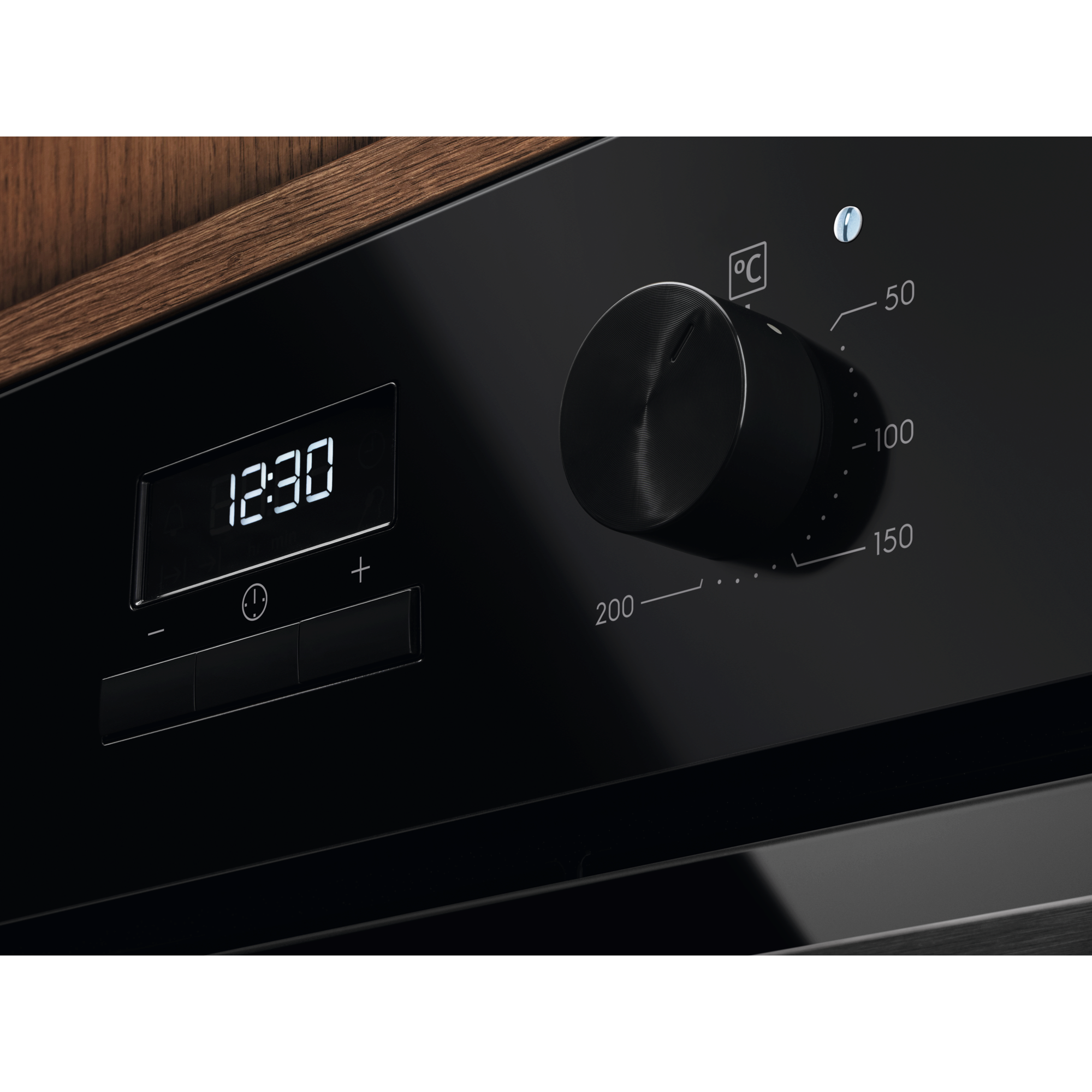 Electrolux KOHGE00BK 60 cm 300 Series built-in single oven, 65 L, angled close-up of the temperature knob and LED display in a timber kitchen cabinet