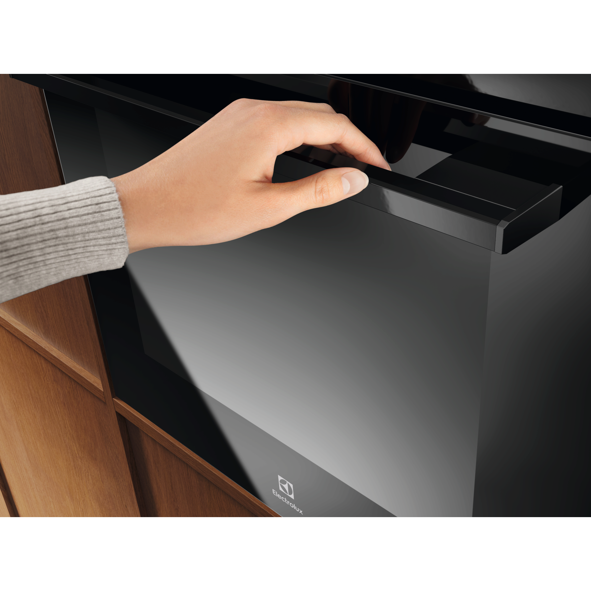 Electrolux KOHGE00BK 60 cm 300 Series built-in single oven, 65 L, close-up of a hand opening the door by the black bar handle