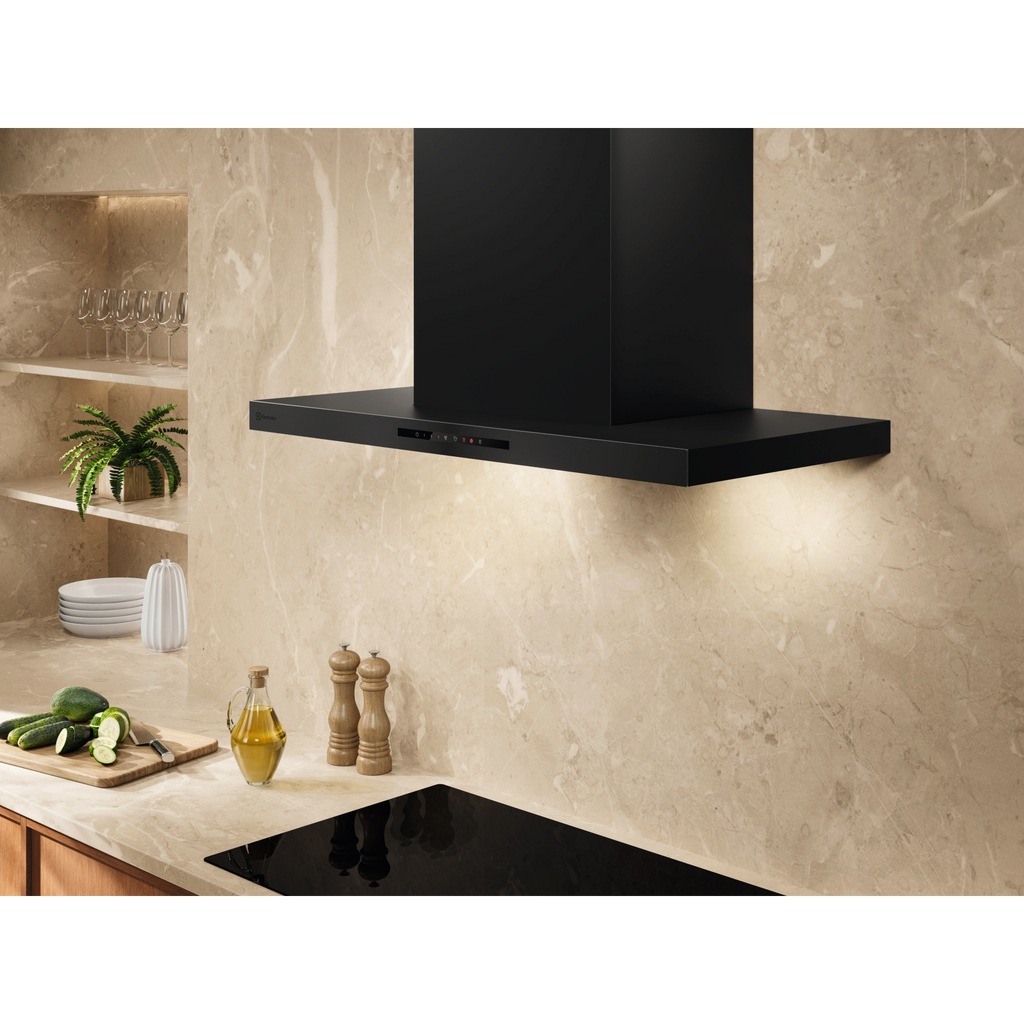 Electrolux ECT9633KB 90 cm 600 Series chimney extractor hood installed above a black hob against a marble splashback, lights on