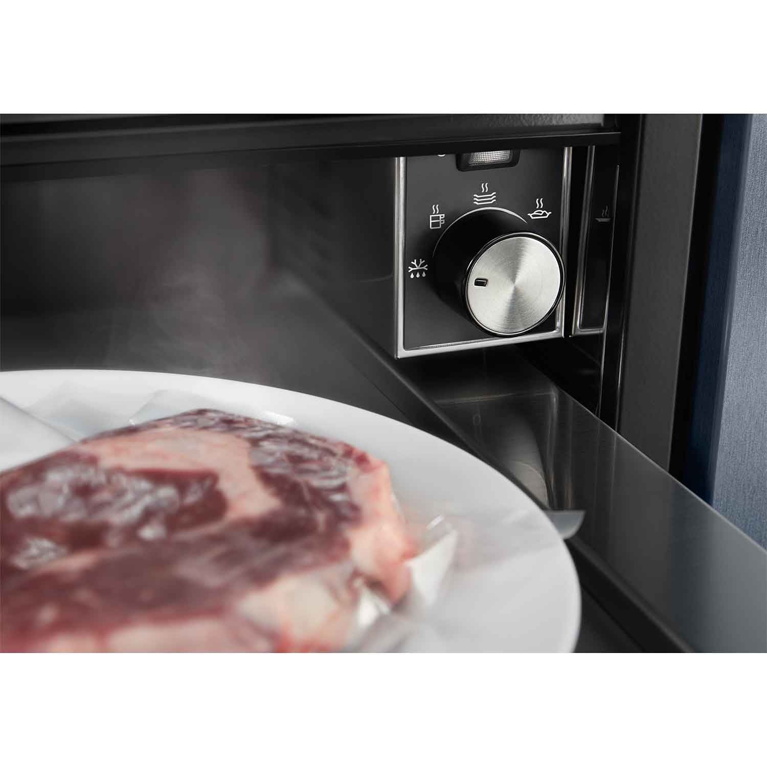 Electrolux KBD4X 60 cm UltimateTaste 700 built-in warming drawer, close-up of the control knob and its five settings with a vacuum-sealed steak on a plate inside